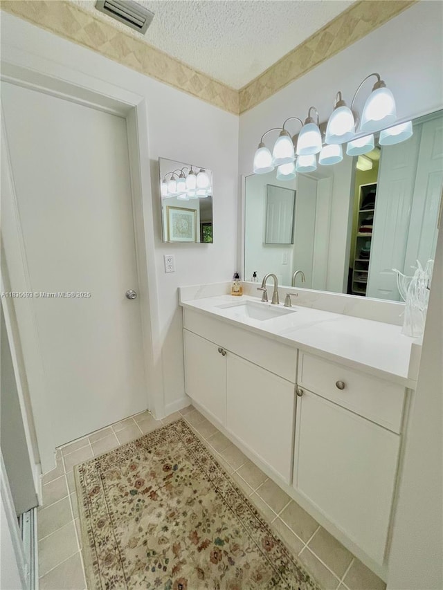 3137 S Carambola Cir S Unit 2369, Coconut Creek, FL 33066 - bathroom featuring tile patterned flooring, vanity, a textured ceiling, and a closet