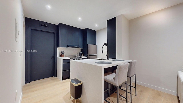 10824 N Kendall Dr Unit S28, Miami, FL 33176 - kitchen with light wood-style flooring, freestanding refrigerator, a kitchen bar, light countertops, and a center island with sink