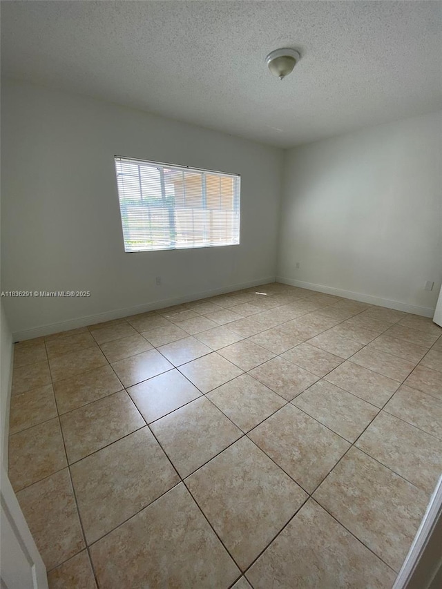 2452 Centergate Dr Unit 103, Miramar, FL 33025 - empty room featuring a textured ceiling and light tile patterned flooring