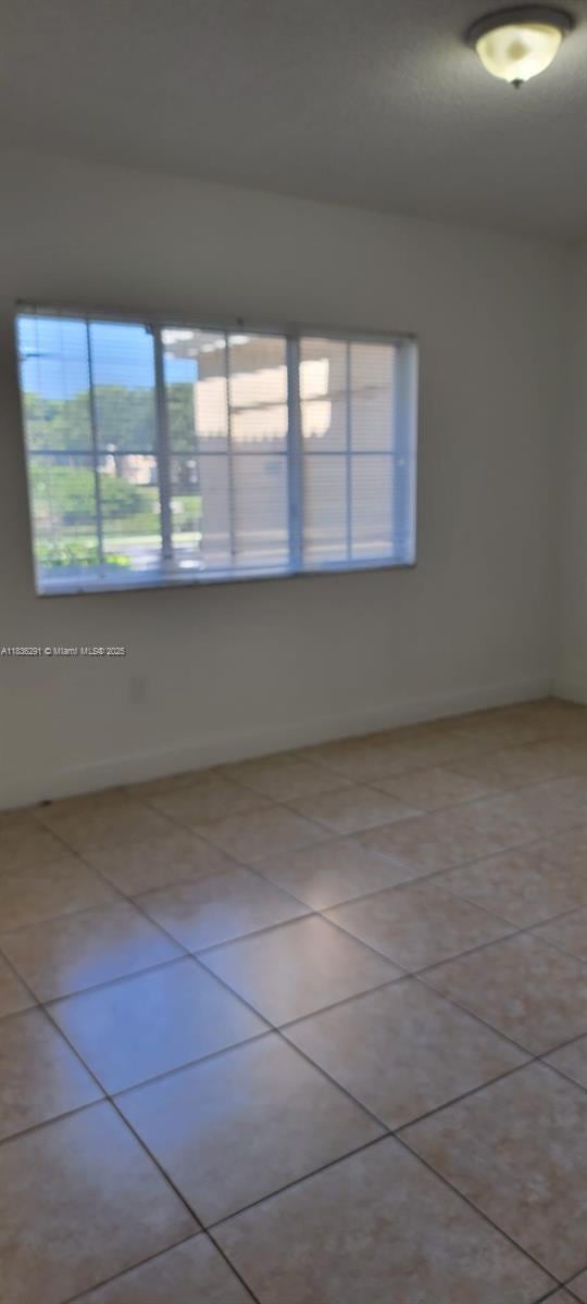 2452 Centergate Dr Unit 103, Miramar, FL 33025 - spare room with plenty of natural light and light tile patterned floors