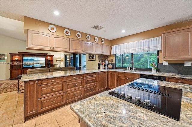 10875 NW 17th Mnr, Coral Springs, FL 33071 - kitchen with black appliances, a peninsula, light stone counters, light tile patterned flooring, and a textured ceiling