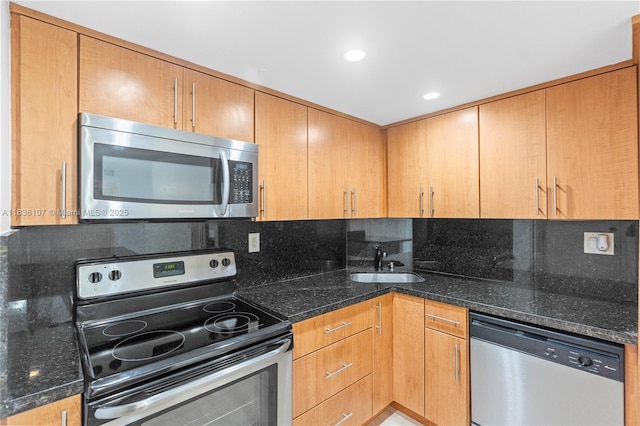 2333 Brickell Ave Unit 1908, Miami, FL 33129 - kitchen featuring appliances with stainless steel finishes, decorative backsplash, and dark stone counters