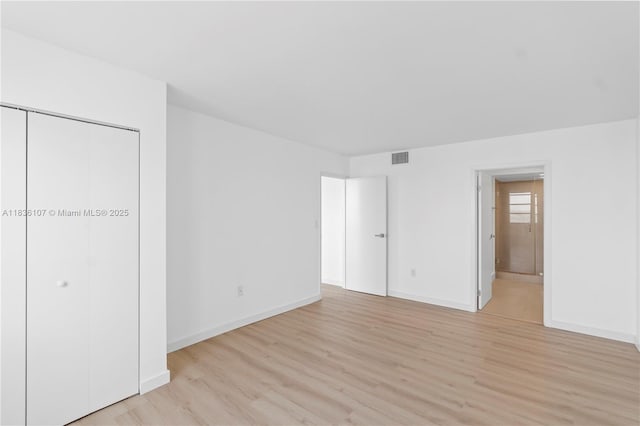 2333 Brickell Ave Unit 1908, Miami, FL 33129 - unfurnished bedroom featuring light wood-style flooring, ensuite bathroom, and a closet