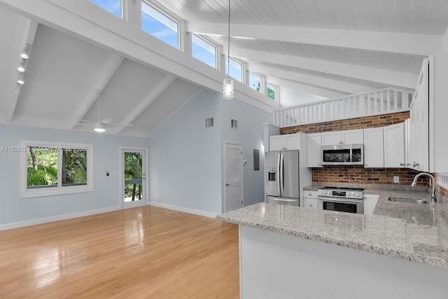 81975 Old Hwy, Islamorada, FL 33036 - kitchen featuring appliances with stainless steel finishes, white cabinets, beamed ceiling, high vaulted ceiling, and light stone countertops