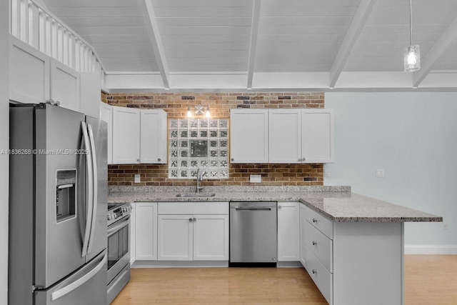 81975 Old Hwy, Islamorada, FL 33036 - kitchen featuring appliances with stainless steel finishes, a peninsula, light wood-style flooring, beamed ceiling, and white cabinets