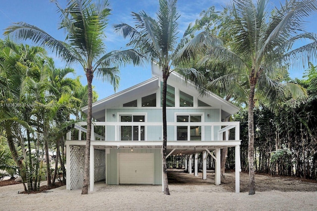81975 Old Hwy, Islamorada, FL 33036 - rear view of property featuring a garage, dirt driveway, a carport, and stairway
