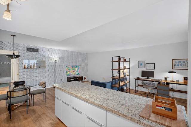 1340 Lincoln Rd Unit 403, Miami Beach, FL 33139 - kitchen featuring open floor plan, white cabinetry, light wood-style flooring, a desk, and wallpapered walls