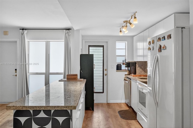 1340 Lincoln Rd Unit 403, Miami Beach, FL 33139 - kitchen featuring white appliances, white cabinetry, light wood-style flooring, and stone countertops