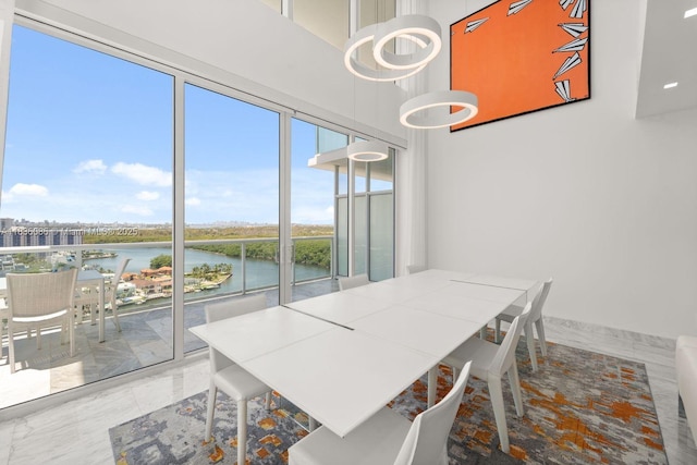 400 Sunny Isles Blvd Unit 2008, Sunny Isles Beach, FL 33160 - dining area featuring a water view, a chandelier, marble finish floors, and a towering ceiling