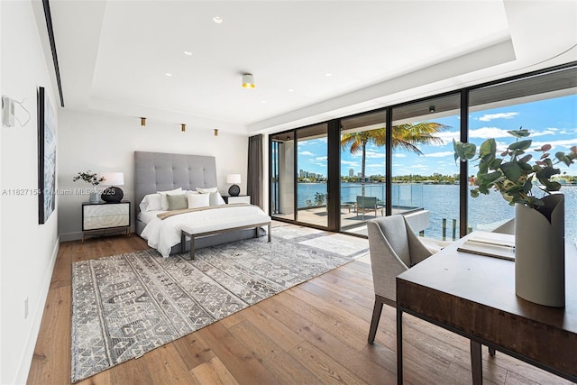 1510 Stillwater Dr, Miami Beach, FL 33141 - bedroom featuring access to exterior, multiple windows, a water view, wood-type flooring, and recessed lighting