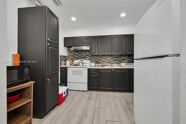 7190 NW 21st Ave, Miami, FL 33147 - kitchen featuring black appliances, under cabinet range hood, light countertops, and backsplash