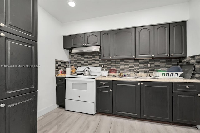7190 NW 21st Ave, Miami, FL 33147 - kitchen with white range with electric stovetop, under cabinet range hood, light countertops, backsplash, and recessed lighting