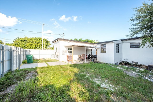 7190 NW 21st Ave, Miami, FL 33147 - back of house featuring stucco siding, a patio area, and a fenced backyard