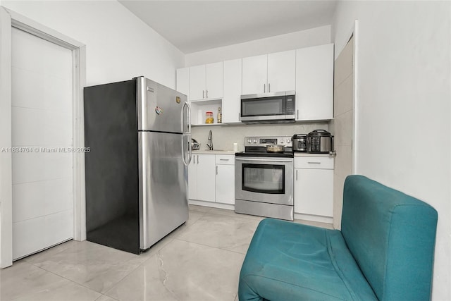 7190 NW 21st Ave, Miami, FL 33147 - kitchen featuring appliances with stainless steel finishes, white cabinetry, backsplash, and light countertops