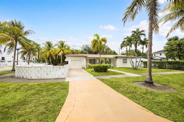 811 SW 25th Rd, Miami, FL 33129 - view of front of property featuring driveway, an attached garage, stucco siding, a tile roof, and a front lawn