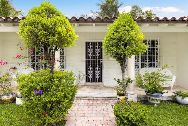 811 SW 25th Rd, Miami, FL 33129 - doorway to property with a tile roof, brick siding, and a porch