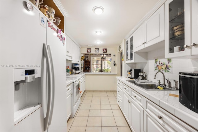 811 SW 25th Rd, Miami, FL 33129 - kitchen with white appliances, white cabinetry, backsplash, light tile patterned floors, and glass insert cabinets