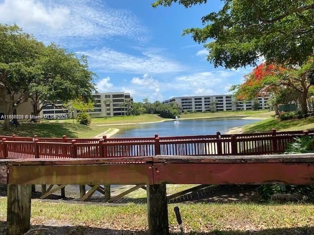 1865 Palm Cove Blvd Unit 9-306, Delray Beach, FL 33445 - dock with a water view and a lawn