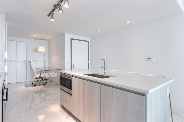 3131 NE 7th Ave Unit 1202, Miami, FL 33137 - kitchen with modern cabinets, light brown cabinets, a center island with sink, light marble finish flooring, and recessed lighting