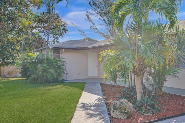 400 NE 2nd St, Boynton Beach, FL 33435 - view of exterior entry with stucco siding and a lawn