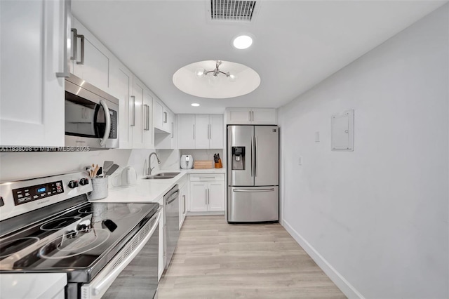 5005 Collins Ave Unit 815, Miami Beach, FL 33140 - kitchen with appliances with stainless steel finishes, white cabinets, light wood finished floors, light countertops, and a chandelier