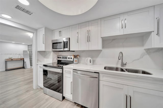 5005 Collins Ave Unit 815, Miami Beach, FL 33140 - kitchen with stainless steel appliances, white cabinets, decorative backsplash, and recessed lighting