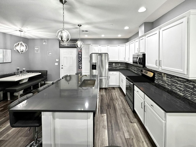4126 Cascada Cir, Cooper City, FL 33024 - kitchen with appliances with stainless steel finishes, dark countertops, dark wood-style floors, a chandelier, and white cabinets