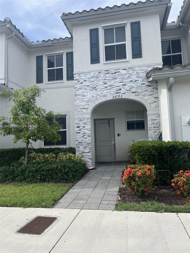 2693 SE 19th St, Homestead, FL 33035 - property entrance featuring stucco siding, stone siding, and a tiled roof