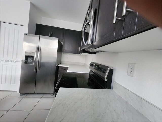 2693 SE 19th St, Homestead, FL 33035 - kitchen with stainless steel appliances, dark cabinetry, light countertops, and light tile patterned flooring