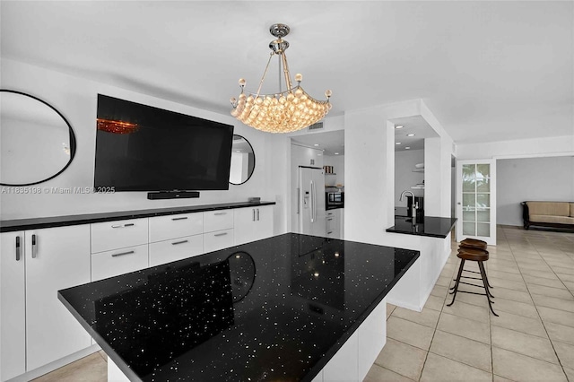 1600 S Bayshore Ln Unit 3A, Coconut Grove, FL 33133 - kitchen with modern cabinets, white cabinetry, white refrigerator with ice dispenser, light tile patterned floors, and a chandelier