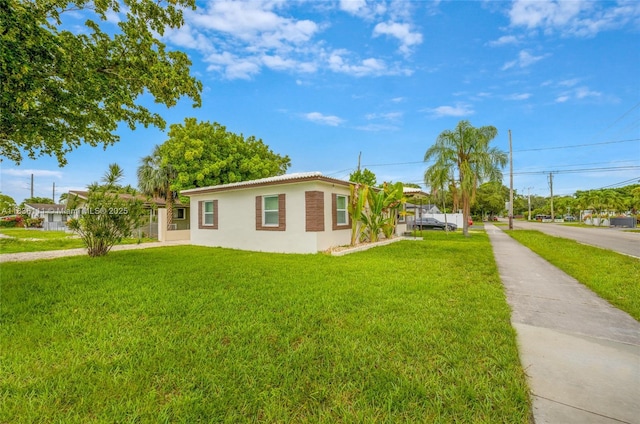 6044 Funston St, Hollywood, FL 33023 - view of property exterior featuring stucco siding, a lawn, and driveway