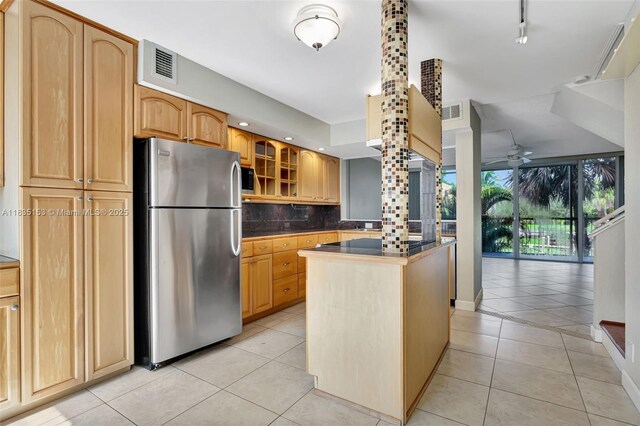 2921 SW 87th Ave Unit 511, Davie, FL 33328 - kitchen with freestanding refrigerator, light tile patterned floors, decorative backsplash, ceiling fan, and glass insert cabinets