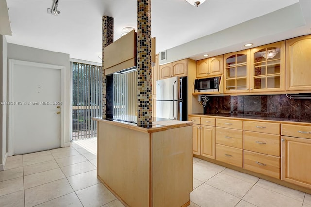 2921 SW 87th Ave Unit 511, Davie, FL 33328 - kitchen featuring black microwave, light brown cabinetry, freestanding refrigerator, glass insert cabinets, and tasteful backsplash