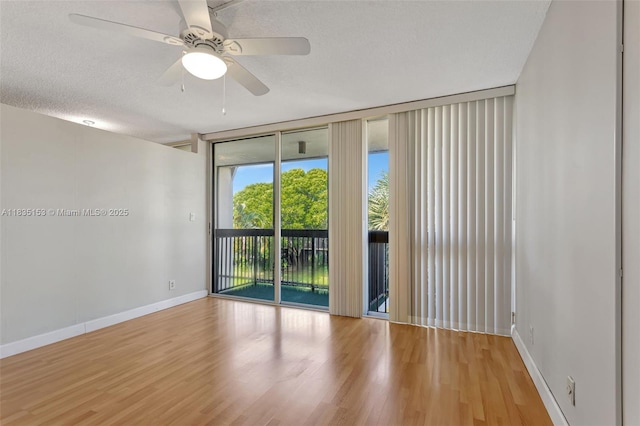 2921 SW 87th Ave Unit 511, Davie, FL 33328 - empty room featuring a wall of windows, wood finished floors, and a ceiling fan