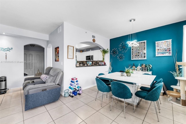 8956 W Flagler St Unit 203, Miami, FL 33174 - dining space featuring arched walkways, an accent wall, and tile patterned flooring
