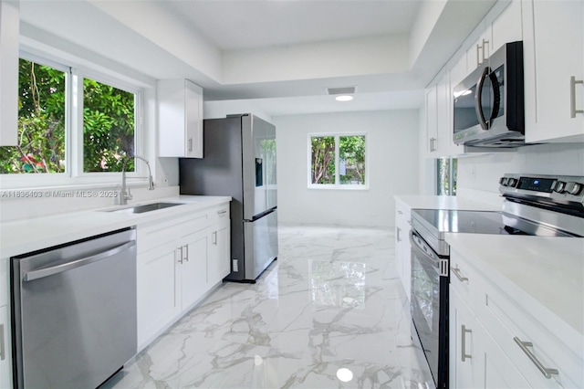 6541 SW 8th St, North Lauderdale, FL 33068 - kitchen featuring appliances with stainless steel finishes, light countertops, a tray ceiling, and white cabinetry