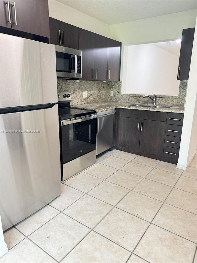 7900 NW 6th St Unit 102, Pembroke Pines, FL 33024 - kitchen with appliances with stainless steel finishes, decorative backsplash, light tile patterned flooring, and light stone countertops