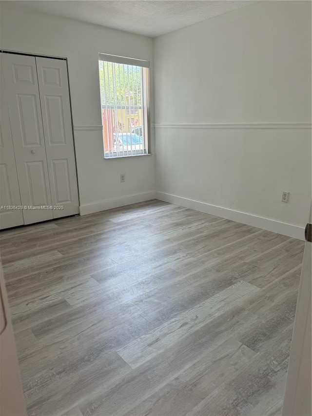 7900 NW 6th St Unit 102, Pembroke Pines, FL 33024 - unfurnished bedroom with wood finished floors, a closet, and a textured ceiling