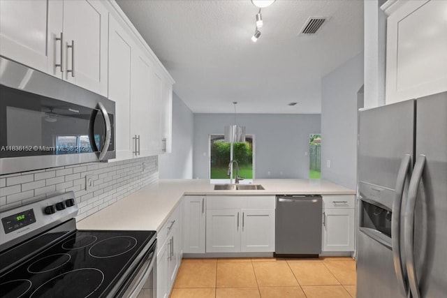 12720 SW 49th Ct, Miramar, FL 33027 - kitchen featuring appliances with stainless steel finishes, decorative backsplash, white cabinets, light tile patterned floors, and light countertops