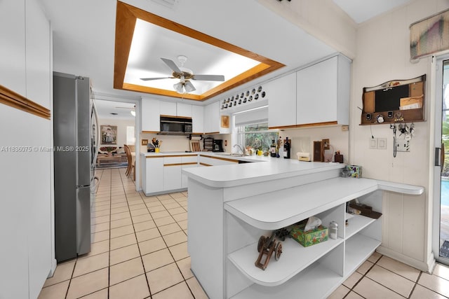15340 SW 82nd Ave, Palmetto Bay, FL 33157 - kitchen featuring freestanding refrigerator, open shelves, black microwave, a tray ceiling, and a peninsula