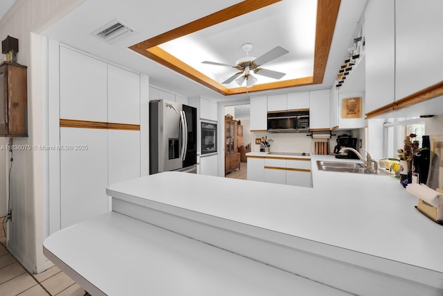 15340 SW 82nd Ave, Palmetto Bay, FL 33157 - kitchen featuring black appliances, a tray ceiling, ceiling fan, and white cabinets