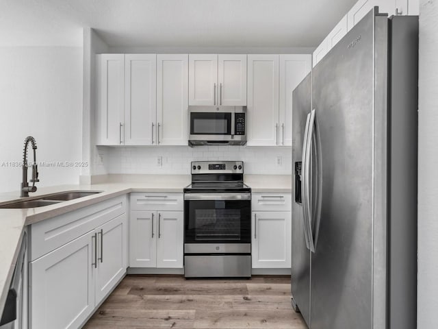1456 SE 26th Ave, Homestead, FL 33035 - kitchen featuring appliances with stainless steel finishes, white cabinetry, light countertops, and light wood-type flooring