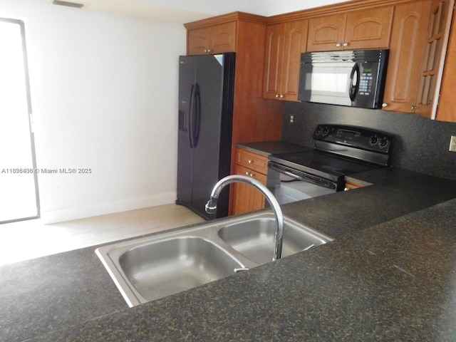 323 Ives Dairy Rd Unit 323-06, Miami, FL 33179 - kitchen featuring black appliances, brown cabinetry, and dark countertops
