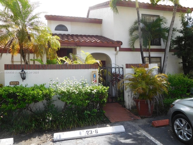 323 Ives Dairy Rd Unit 323-06, Miami, FL 33179 - mediterranean / spanish home featuring stucco siding, a tiled roof, and uncovered parking