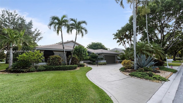 9099 NW 47th Ct, Coral Springs, FL 33067 - view of front of home featuring a front yard, driveway, a tiled roof, and stucco siding