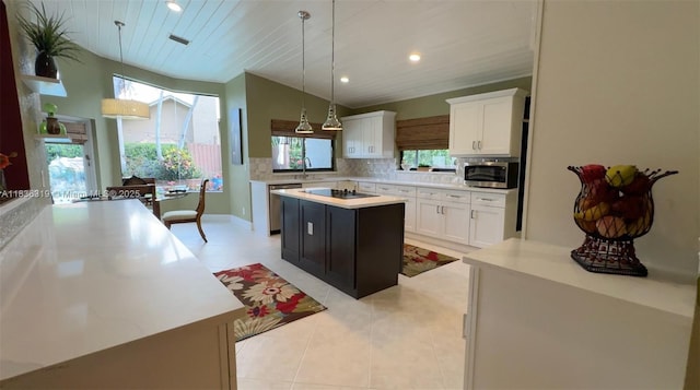 9099 NW 47th Ct, Coral Springs, FL 33067 - kitchen with stainless steel appliances, a center island, light countertops, backsplash, and white cabinetry