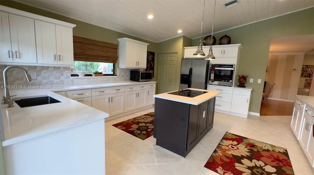 9099 NW 47th Ct, Coral Springs, FL 33067 - kitchen with appliances with stainless steel finishes, a center island, decorative backsplash, light countertops, and white cabinets