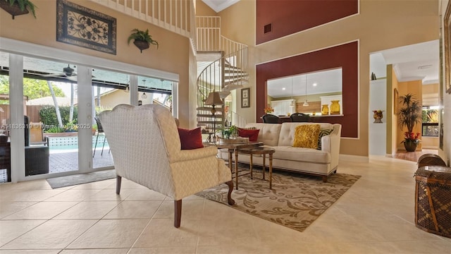 9099 NW 47th Ct, Coral Springs, FL 33067 - tiled living room with ornamental molding, a towering ceiling, and stairs