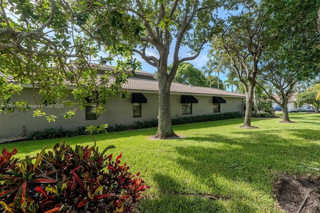 9099 NW 47th Ct, Coral Springs, FL 33067 - back of property featuring stucco siding, a lawn, and a tile roof