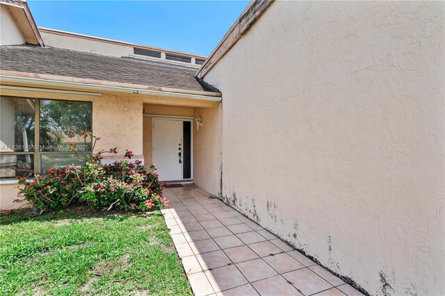 8250 NW 51st Ct, Lauderhill, FL 33351 - view of exterior entry with stucco siding and roof with shingles